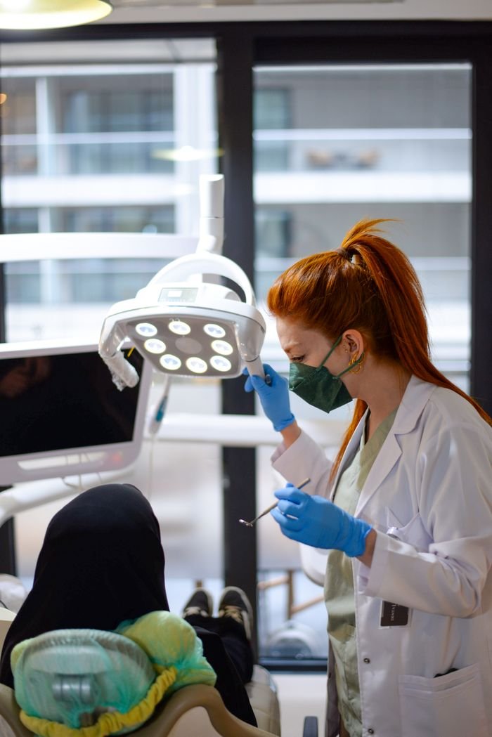Mastering the First Impression: Your intriguing post title goes here Female dentist attends to a patient in İstanbul clinic, focusing on dental procedure.