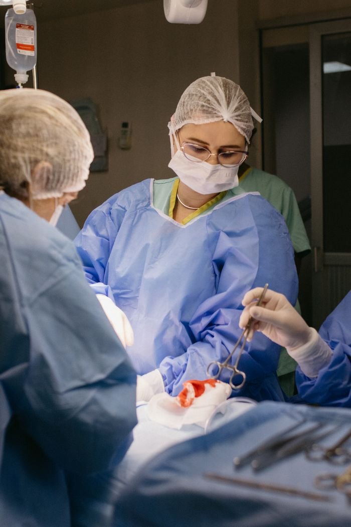Medical professionals performing surgery in a hospital operating room, showcasing teamwork and precision.